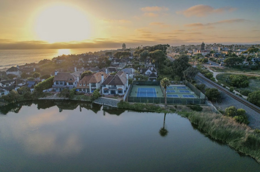 Aerial of Buena Vista Lagoon at sunset with the courts and community rooftops