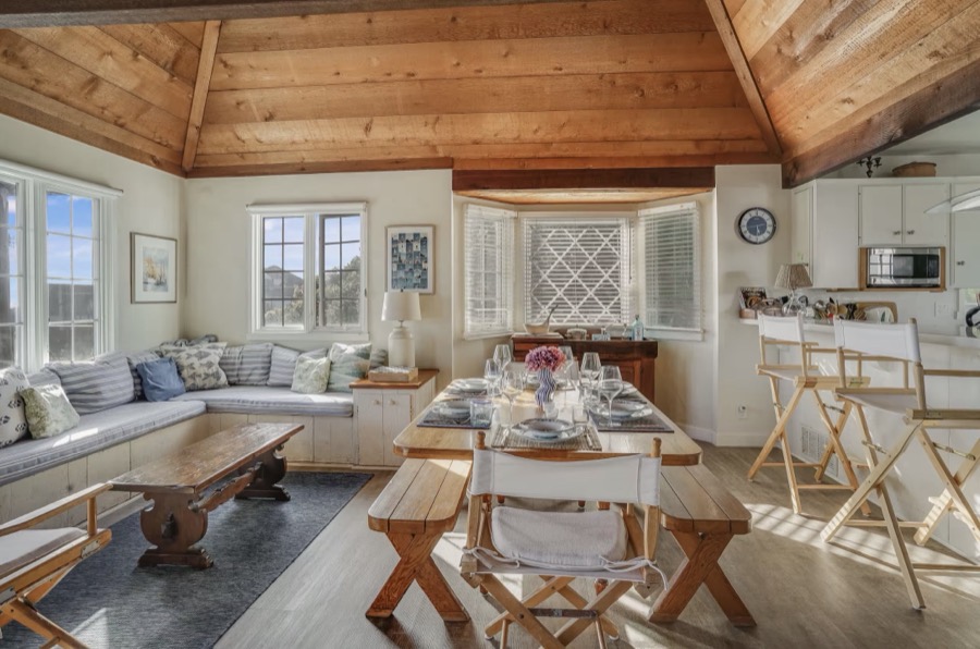 The living room with deep sofas, open beams and light from three sides